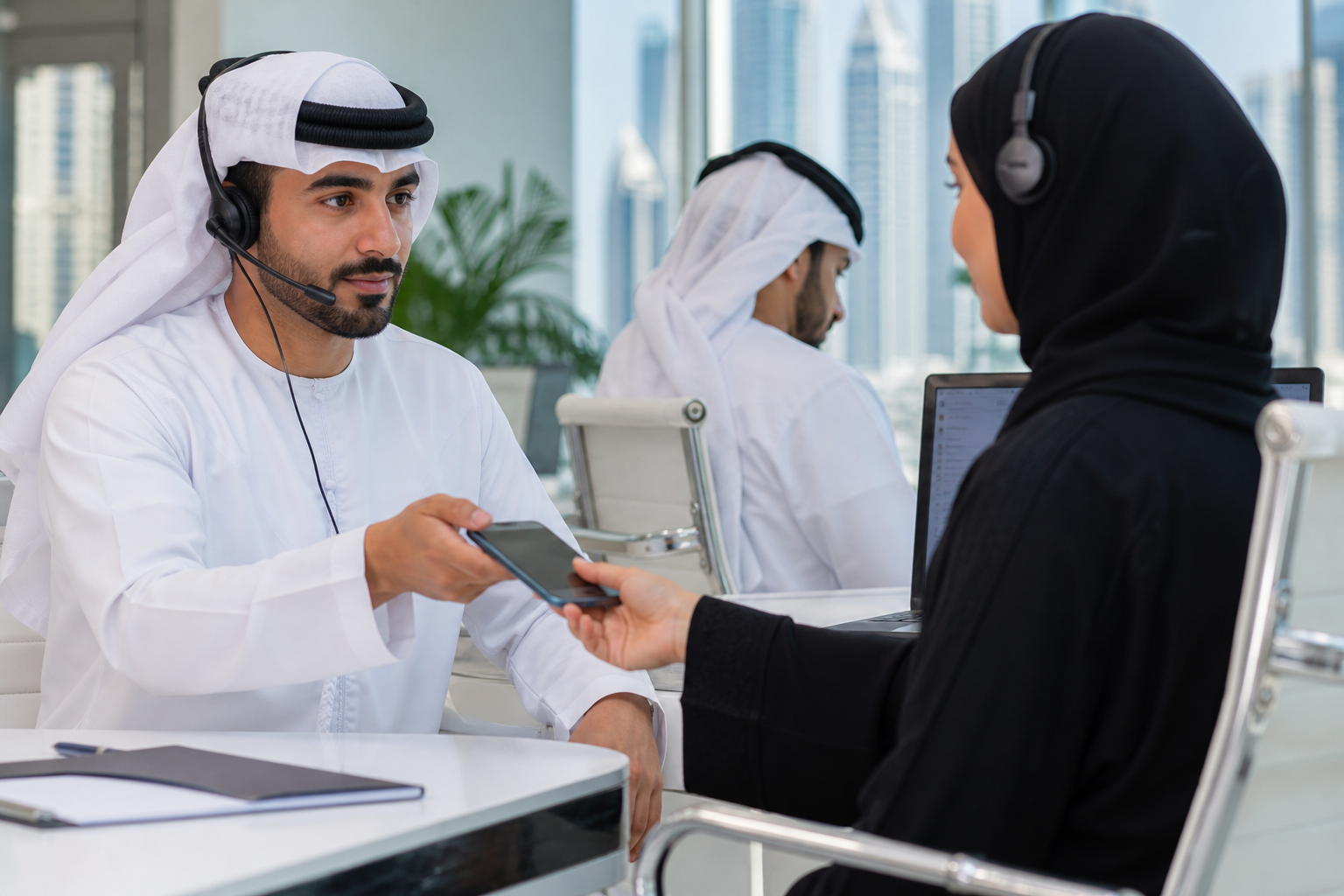 موظفان عربيان في فريق خدمة إماراتي يراجعان محادثة واتساب قبل تسلمها بشرياً